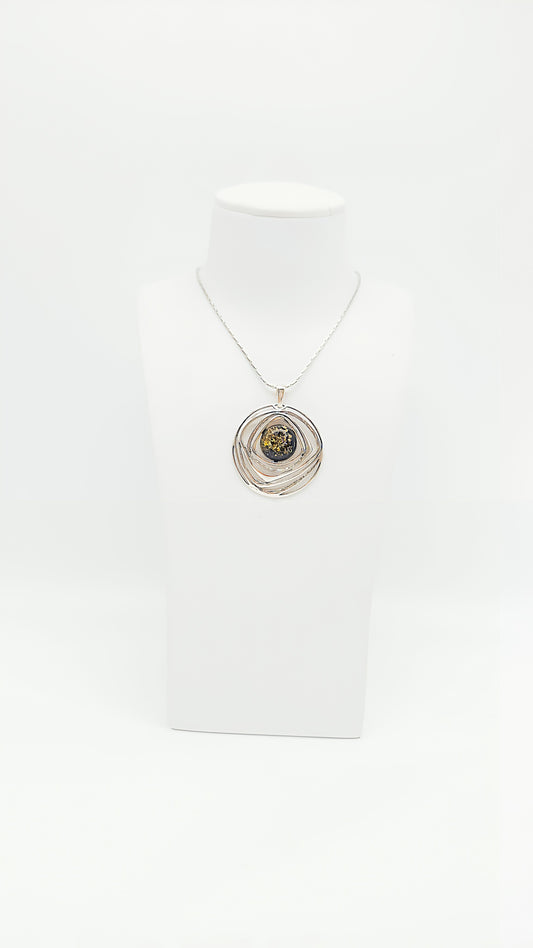 Modern form meets natural shine: Green amber in a silver frame