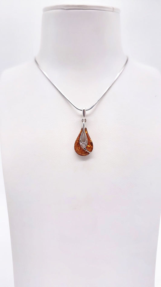 Drop-shaped natural amber in an artistic silver setting