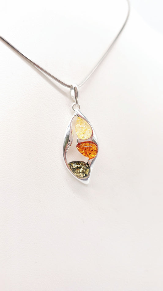 Exquisite pendant with amber in various colors and silver