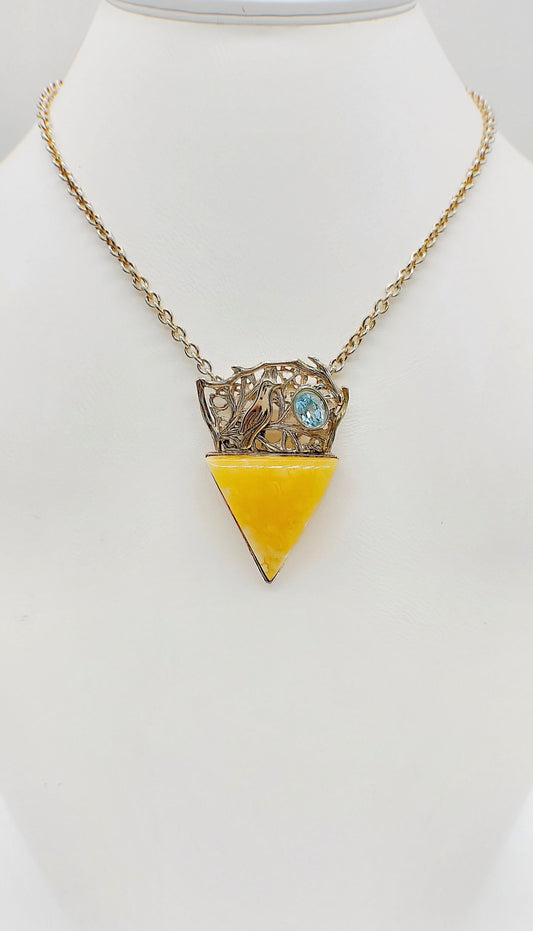 Triangular royal amber pendant with small topaz