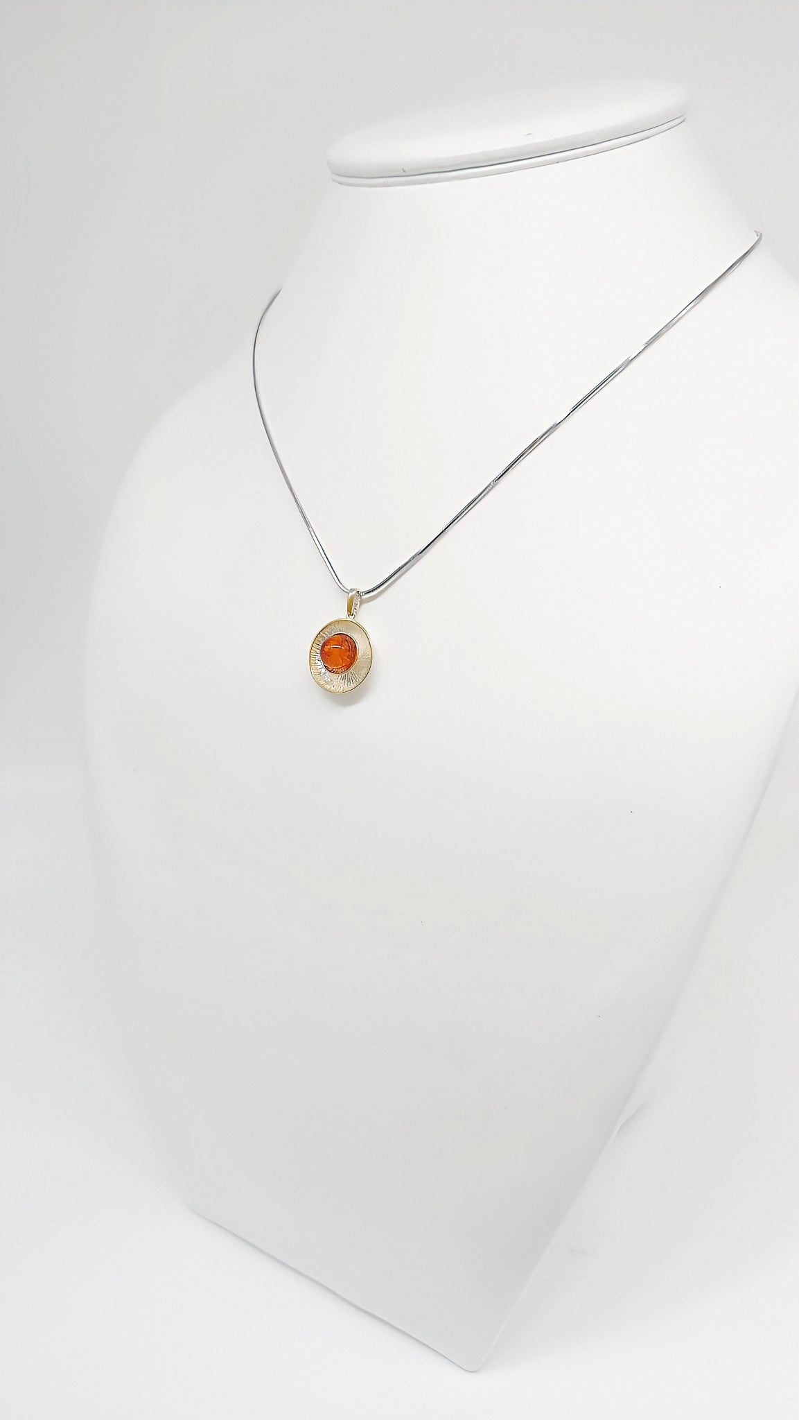 Stylish pendant made of silver, amber and gold-plated details