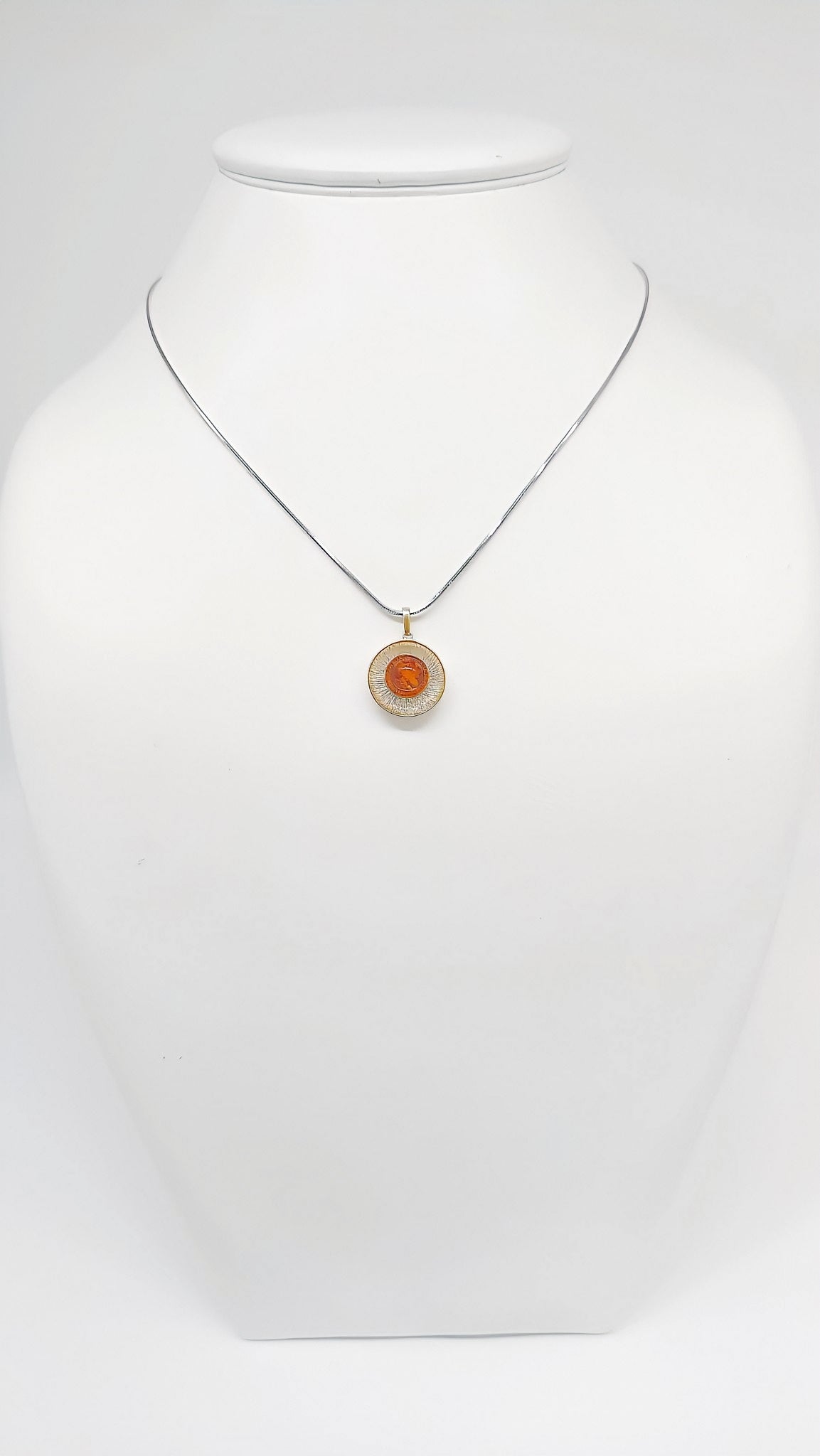 Stylish pendant made of silver, amber and gold-plated details