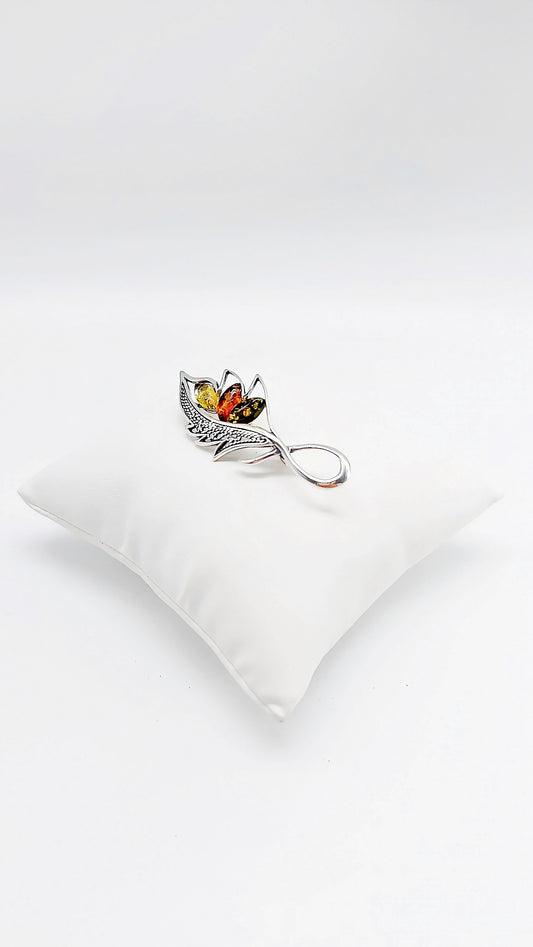 Filigree silver brooch with multicolored amber