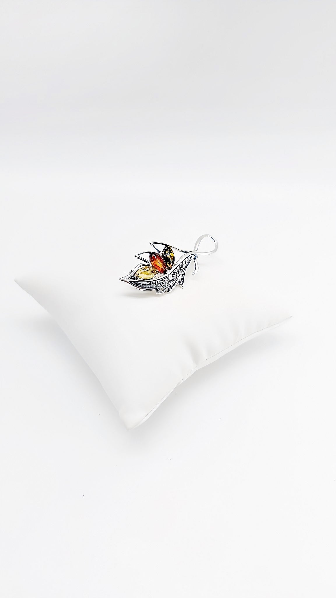 Filigree silver brooch with multicolored amber