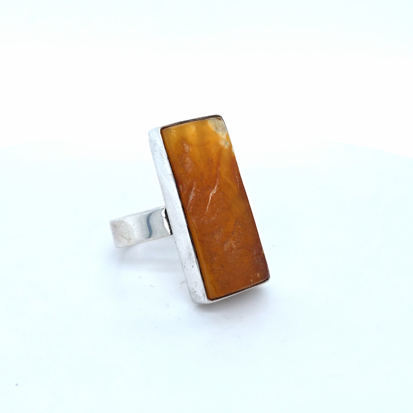 Ästhetischer länglicher Ring mit gemustertem Naturbernstein