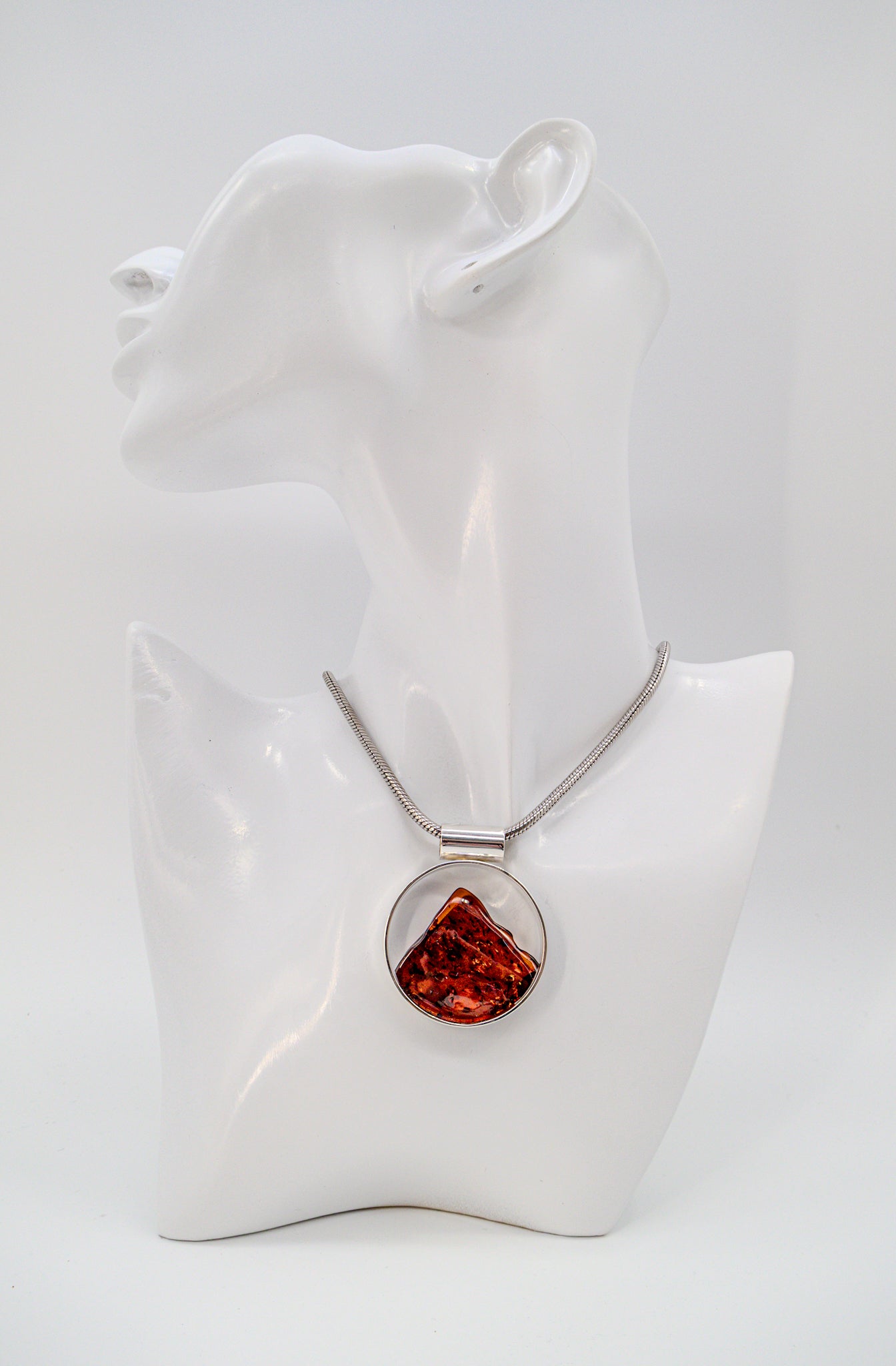 Round setting silver pendant with genuine amber