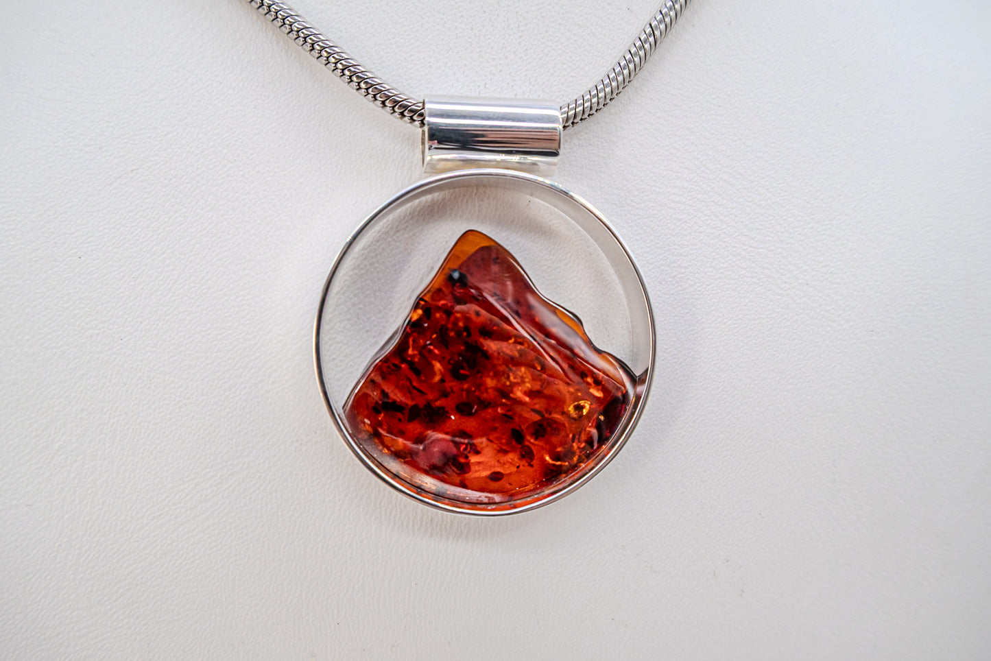 Round setting silver pendant with genuine amber