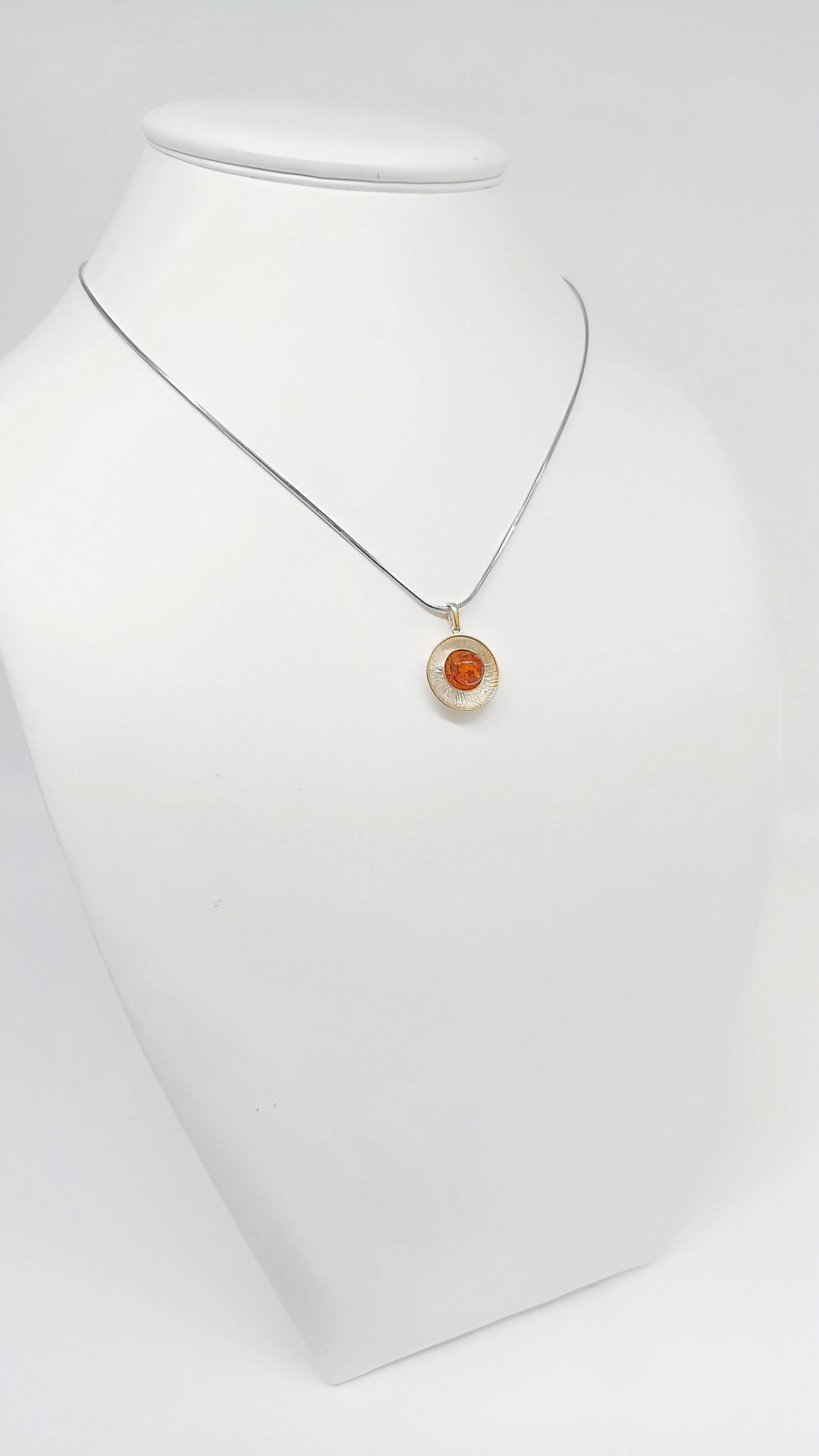 Stylish pendant made of silver, amber and gold-plated details